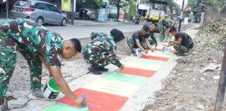 Guyub Rukun, Satgas TMMD Reguler Ke-125 Kodim 0735/Surakarta Laksanakan Pengecatan Lis Jalan Dan Penutup Saluran Air