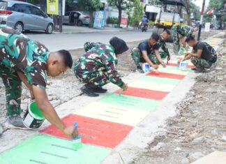 Guyub Rukun, Satgas TMMD Reguler Ke-125 Kodim 0735/Surakarta Laksanakan Pengecatan Lis Jalan Dan Penutup Saluran Air