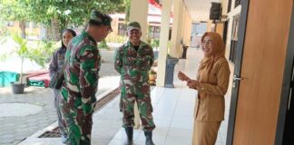 Babinsa Kratonan ngobrol santai dengan kepala sekolah di sela kegiatan belajar mengajar