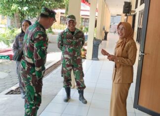 Babinsa Kratonan ngobrol santai dengan kepala sekolah di sela kegiatan belajar mengajar